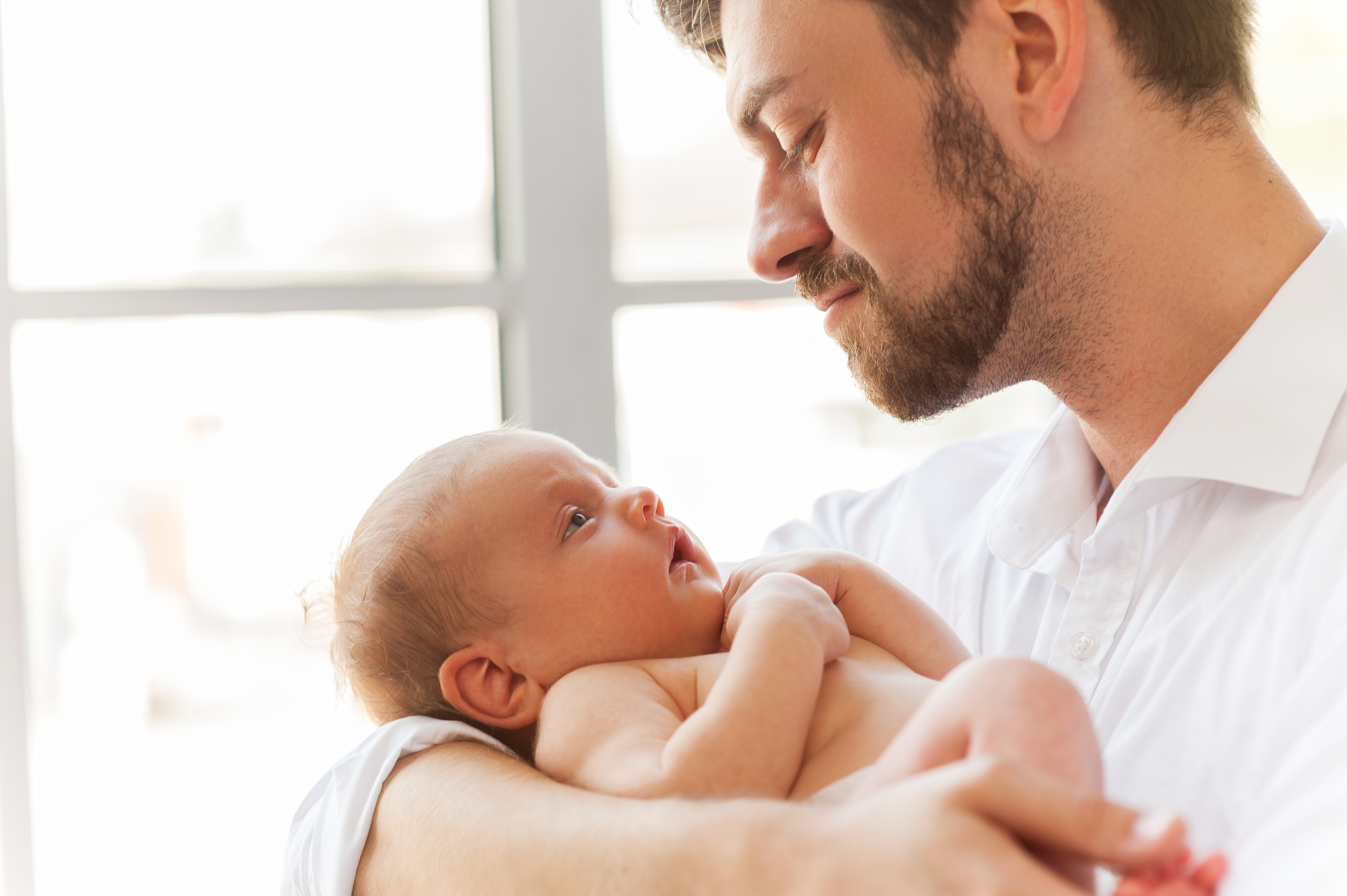 Dad holding a baby more confidently after receiving support from a postpartum doula
