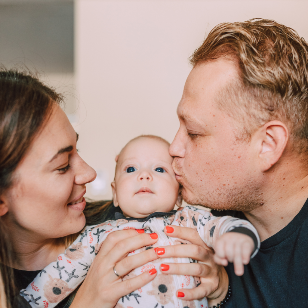 Couple holding a baby between them